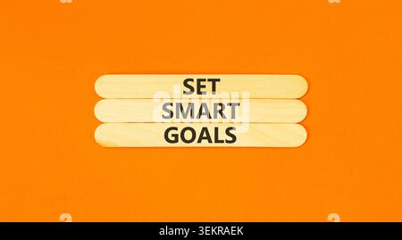 Set smart goals words symbol. Concept words Set smart goals on beautiful wooden sticks. Beautiful orange background. Business and set smart goals conc Stock Photo