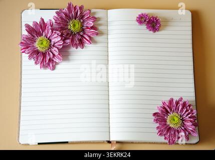 An open lined notebook decorated with pink flowers chrysanthemums. High quality photo Stock Photo