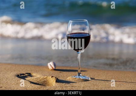 Coastal Relaxation Concept Wine Glass by Ocean Waves Stock Photo