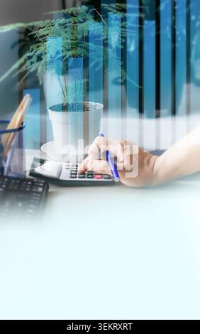 A businessman works on an accounting report using a calculator, with a potted plant nearby. A focused man makes financial calculations and plans a bud Stock Photo