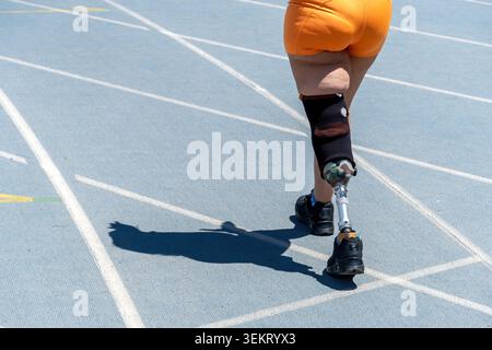 Amputee athlete using prosthetic leg on running track Stock Photo