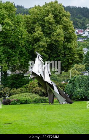 Bergen, Norway - July 7, 2024: Modern abstract metal sculpture in city park surrounded by lush. Stock Photo