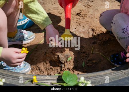 kids playing with sand and water in a sandbox Stock Photo