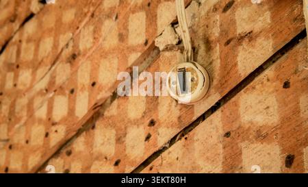 Old electrical switch on a wooden wall with exposed wiring Stock Photo