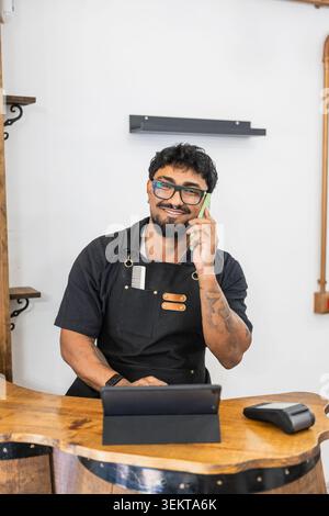 Barbershop owner talking on phone checking bookings Stock Photo