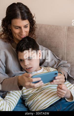 Mother and son with cerebral palsy using smartphone Stock Photo