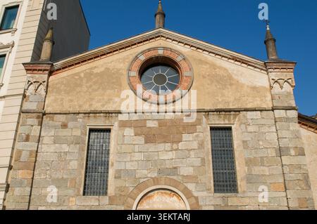 Architectural close up of the historical stone facade, pinnacles and terracotta rose window of the renaissance Santa Maria degli Angeli church. Stock Photo