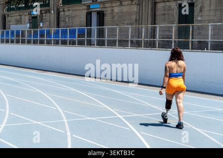 Woman with prosthetic leg walking on track Stock Photo