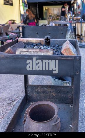 Traditional blacksmith tools with a heavy steel anvil, hammer, and vintage metal tongs on a rustic wooden workbench. Professional forging equipment. M Stock Photo