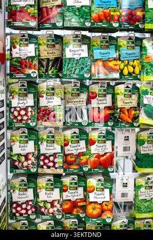 Dijon France June 3 2026. A variety of colorful paper seed packets for tomato parsley radish and cucumber hanging on a retail display stand in a store Stock Photo