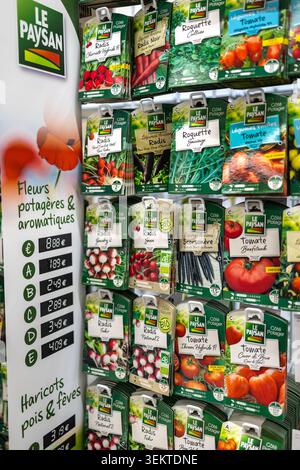 Dijon France June 3 2026. A variety of colorful paper seed packets for tomato parsley radish and cucumber hanging on a retail display stand in a store Stock Photo
