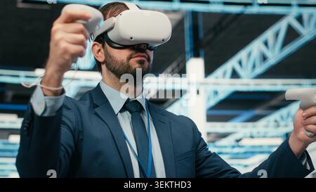Data center programmer using VR headset tech to do equipment resource optimization. Server farm IT professional using virtual reality simulation to upgrade hardware supercomputers, camera B Stock Photo