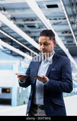 Doing quality control, semiconductor substrates and businessman in microchip foundry cleanroom. Analyzing hardware production lines output, silicon wafers and nanotechnology RD facility director Stock Photo