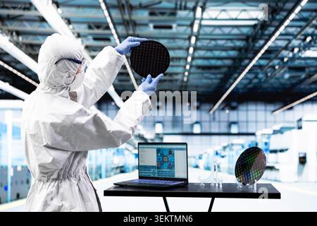 Processing silicon wafer, EDA software and engineer man in automated manufacturing facility. Inspecting delicate microelectronic hardware, laptop program and technician doing quality control Stock Photo