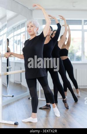 Group of women practicing at ballet barre Stock Photo