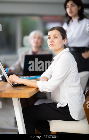 Middle-aged woman watching project presentation in modern office Stock Photo