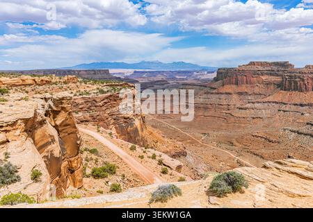 High angle view of the rugged unpaved Shafer Trail Road winding down through steep red rock cliffs in Canyonlands, Utah. Stock Photo