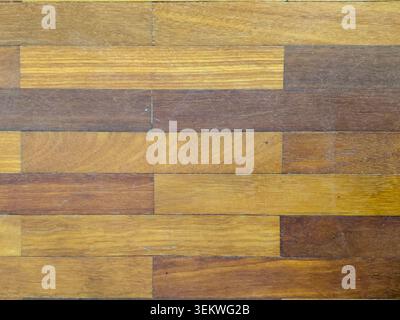 A high-angle, horizontal full-frame view of an aged brown hardwood parquet floor showing a multi-toned brick pattern, organic timber grains, and fine Stock Photo