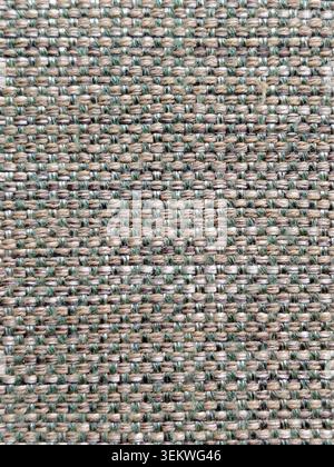 A detailed full-frame background texture of textured woven fabric, featuring a close-up pattern of interlocked beige, tan, and green threads perfect f Stock Photo