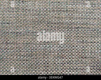 A detailed full-frame background texture of a textured woven fabric, showing a horizontal patterned layout of interlocked beige, tan, and green thread Stock Photo