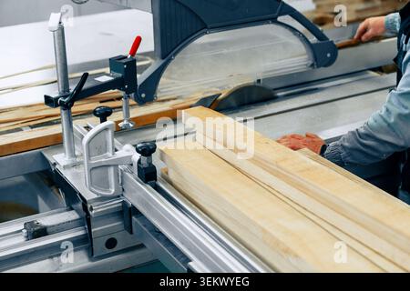 Workers cut wood in furniture workshop during daytime for furniture making projects Stock Photo
