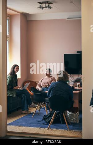Female and male business executives planning strategies with each other while working in office Stock Photo