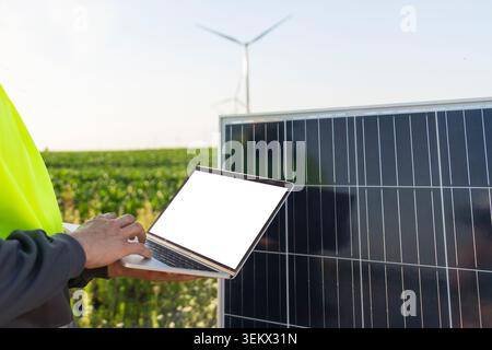 Engineer with laptop next to solar panel Stock Photo