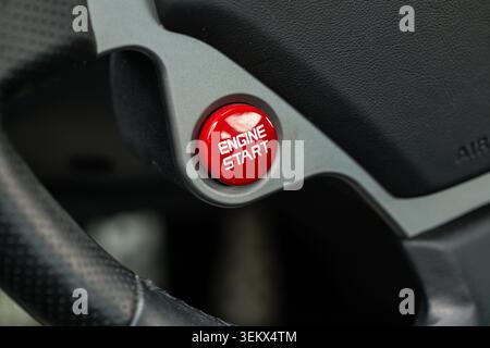 Lucerne, Switzerland, May 30, 2026. Macro shot captures the textured red plastic surface and bold white typography of the engine start button integrat Stock Photo