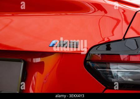 Lucerne, Switzerland, May 30, 2026. Extreme close-up view focuses on the glossy black M2 model insignia with its iconic tricolor bars on the red metal Stock Photo