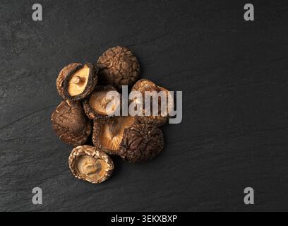Dry Shiitake Mushrooms, Raw Shitake Pile, Healthy Organic Asian Fungi, Common Chinese Edible Shiitake Mushroom on Black Background Top View Stock Photo