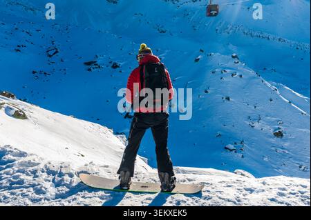 Bonneville, France - December 24, 2017. Impressive mountain scenery from the Aiguille du Midi in the French alps. A person wearing a red jacket is descending down the mountain on a snowboard Stock Photo