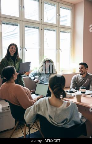 Group of tech experts talking with each other in business meeting at startup office Stock Photo
