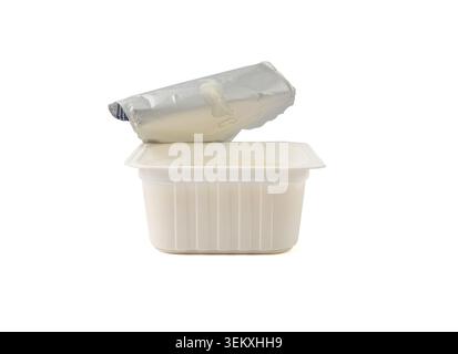 Yogurt cup isolated, yoghurt with orange fruits pieces in plastic pot, milk pudding container, dairy food small package on white background Stock Photo