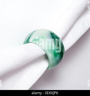 Green marble pattern napkin ring on white fabric napkin Stock Photo