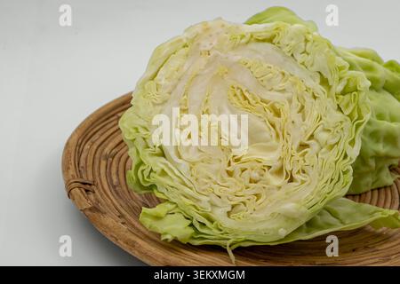 Half Of Fresh Green Cabbage On Wicker Tray Isolated On White Background Stock Photo