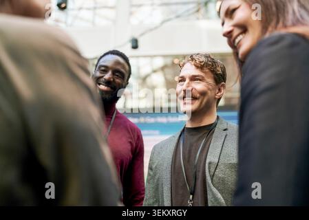 Smiling male business expert engaging with colleagues in conference at convention center Stock Photo