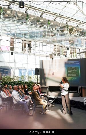 Male and female business associates listening to speaker while attending seminar at convention hall Stock Photo