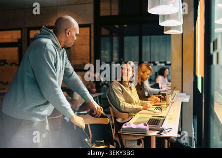 Diverse business colleagues interacting with each other at workspace Stock Photo