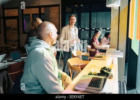 Diverse colleagues interacting and working in modern coworking hub Stock Photo