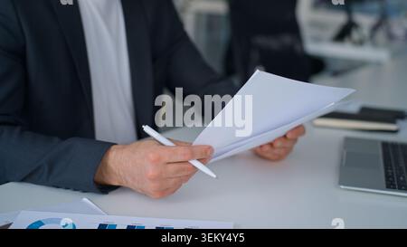 Male hands writing notes in paper with charts graphs near laptop on office table business man busy with data analysis process businessman write Stock Photo