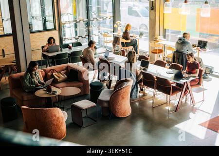 High angle view of diverse professionals working on laptops in modern coworking space Stock Photo