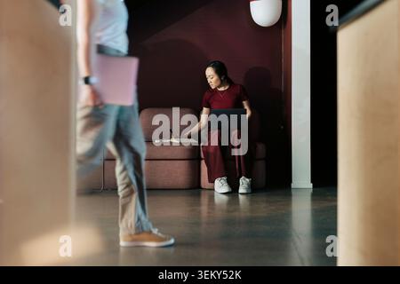 Businesswoman writing notes in diary while sitting and working with laptop at coworking space Stock Photo