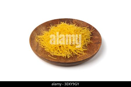 Raw vermicelli on wood plate isolated, gold soup pasta round pile, small homemade noodles, thin macaroni, Italian filini pasta on white background Stock Photo