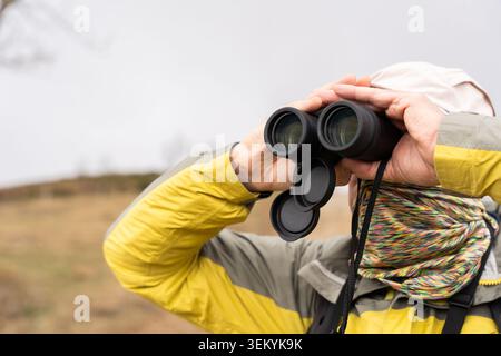 Healthy retirement lifestyle concept with a man scouting the horizon on an outdoor adventure Stock Photo