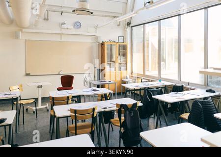 Empty desks and chairs in classroom at junior high school Stock Photo