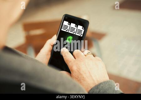 Woman Approving Documents on Smartphone with Fingerprint Authentication. Digital workflow, remote work, document management, online business approval. Stock Photo