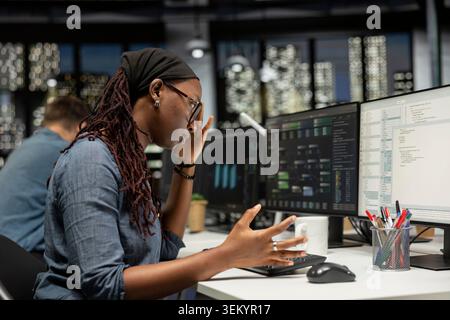 Engineer feeling disappointed in startup office after noticing error in machine learning code while doing quality assurance. IT specialist disapproving of mistakes in AI written programming language Stock Photo