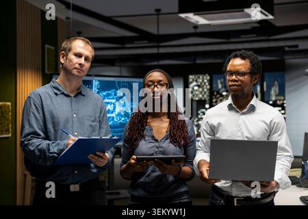 Portrait of programmers in tech startup office developing apps using AI automation. Team of IT professionals working on devices, debugging applications with artificial intelligence Stock Photo