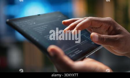 Close up of Silicon Valley company data scientist in office developing apps with device. Employee using deep learning tech on tablet at work to debug applications and resolve issues Stock Photo
