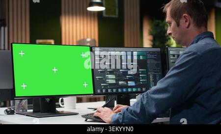 Green screen PC used by Silicon Valley company developer in office developing apps. Worker using deep learning tech on chroma key computer at work to debug applications and resolve issues Stock Photo